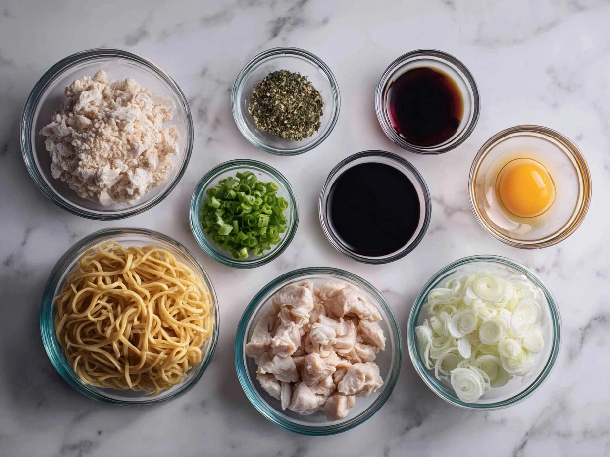 Ingredients for One-Pan Chicken Lo Mein including chicken, onion, garlic, bell pepper, carrots, broccoli, noodles, and sauces.